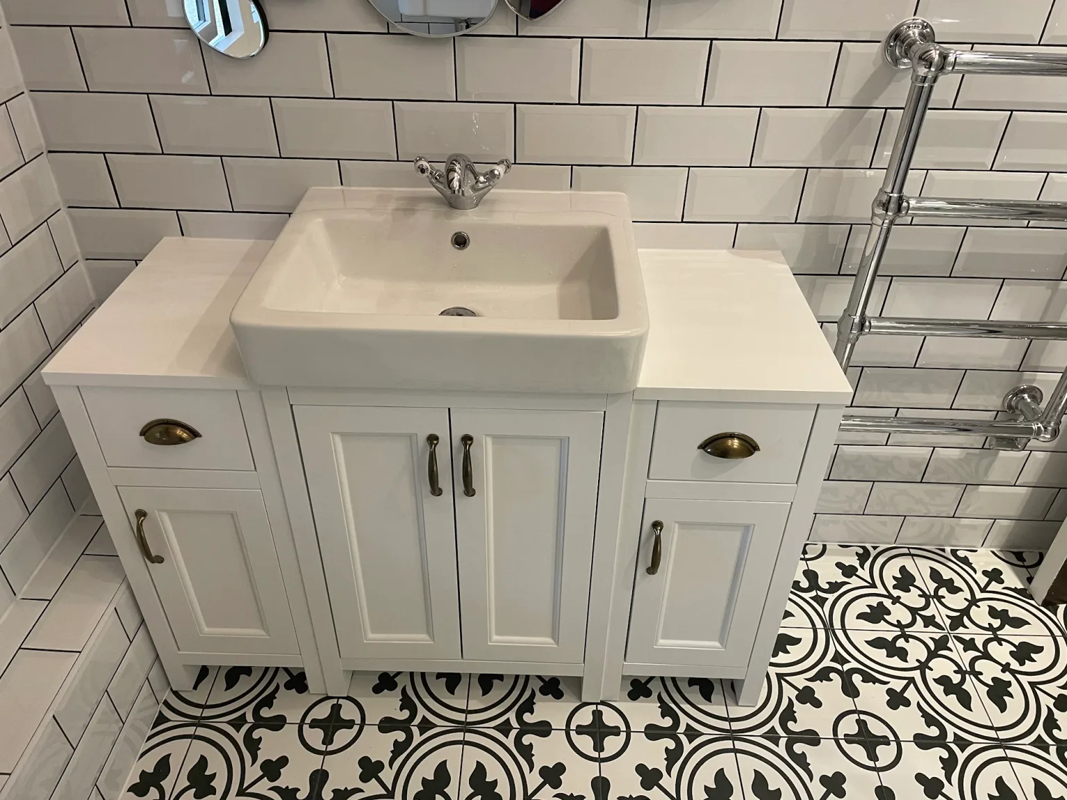 Completed client shower room with patterned floor tiles and white metro wall tiles