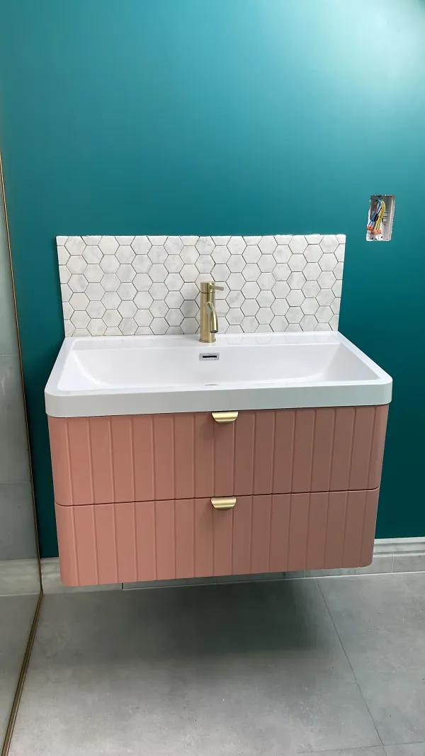 Finished vanity with a teal wall and hexagonal splashback